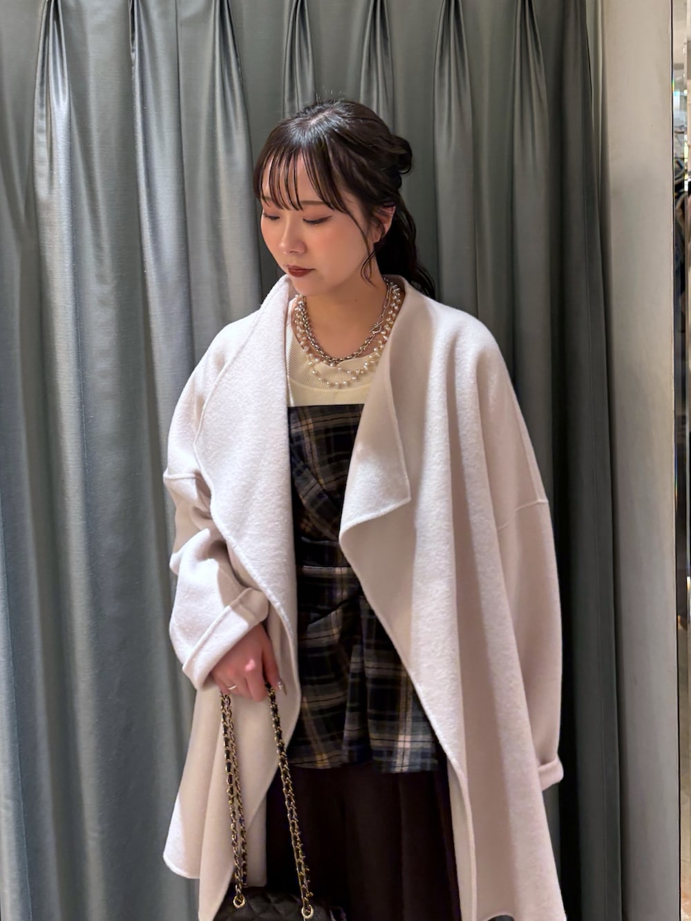 ブラウン系のスラックス、ブラウン系のショルダーバッグ、ブラック系のその他トップスを着用したレディースの冬コーディネートの3枚目の写真