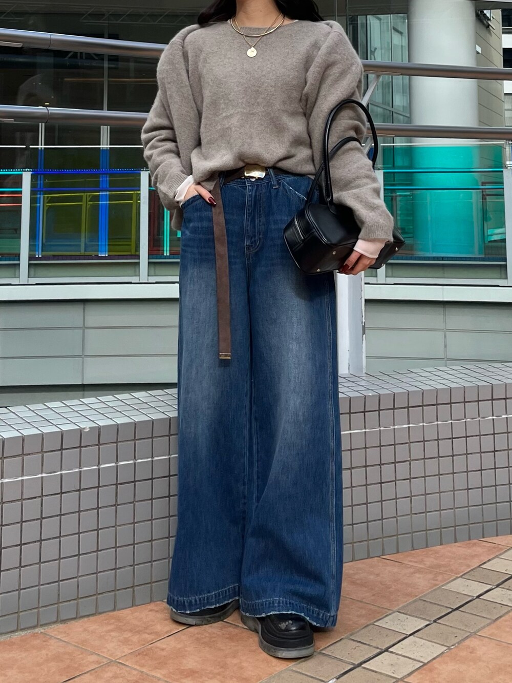 ブルー系のデニムパンツ、ブラウン系のニット/セーター、ブラウン系のカーディガン/ボレロを着用したレディースの冬コーディネートの3枚目の写真