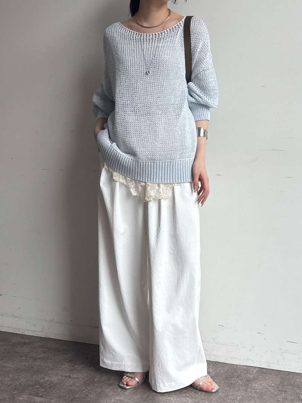 ブルー系のニット/セーター、シルバー系のネックレスを着用したレディースの春コーディネートの2枚目の写真