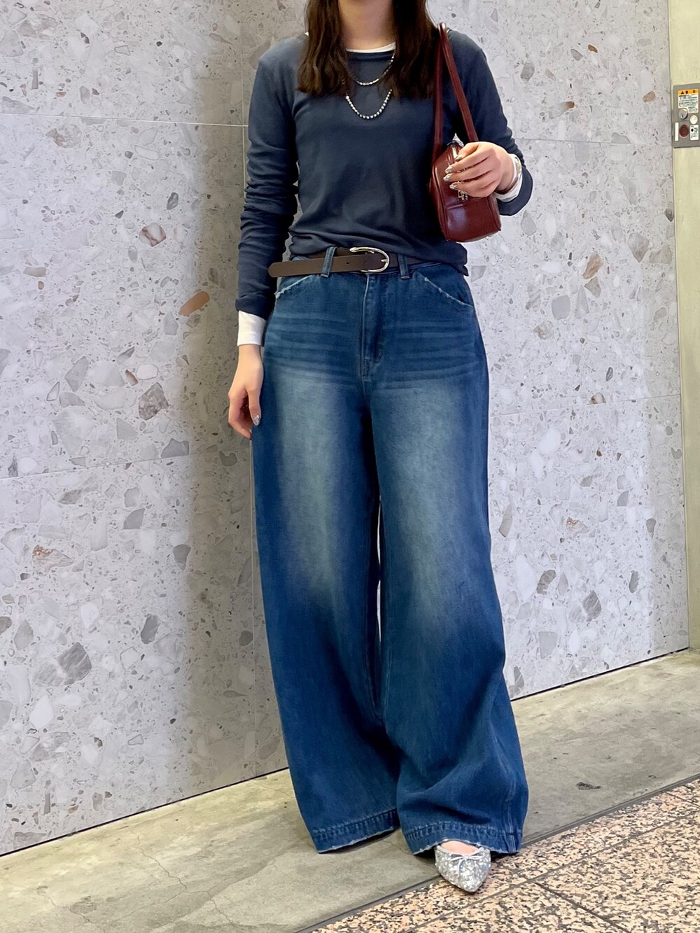 ブルー系のデニムパンツ、シルバー系のパンプス、ホワイト系のTシャツ/カットソーを着用したレディースの秋コーディネートの2枚目の写真