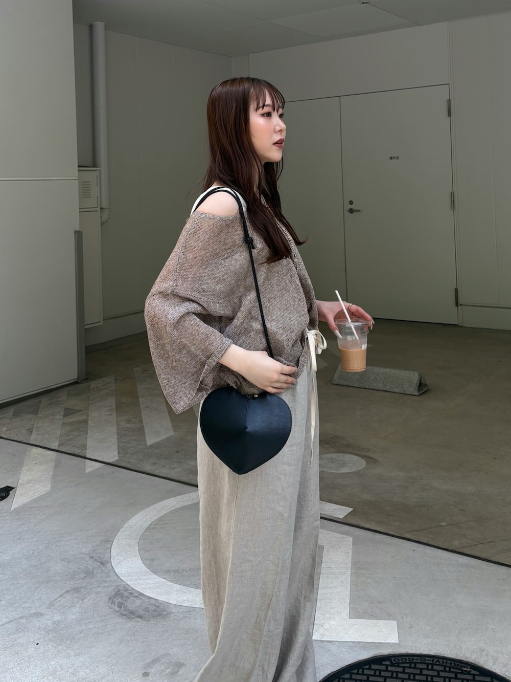 ベージュ系のその他パンツ、ベージュ系のニット/セーター、ブラック系のショルダーバッグを着用したレディースの春コーディネートの2枚目の写真