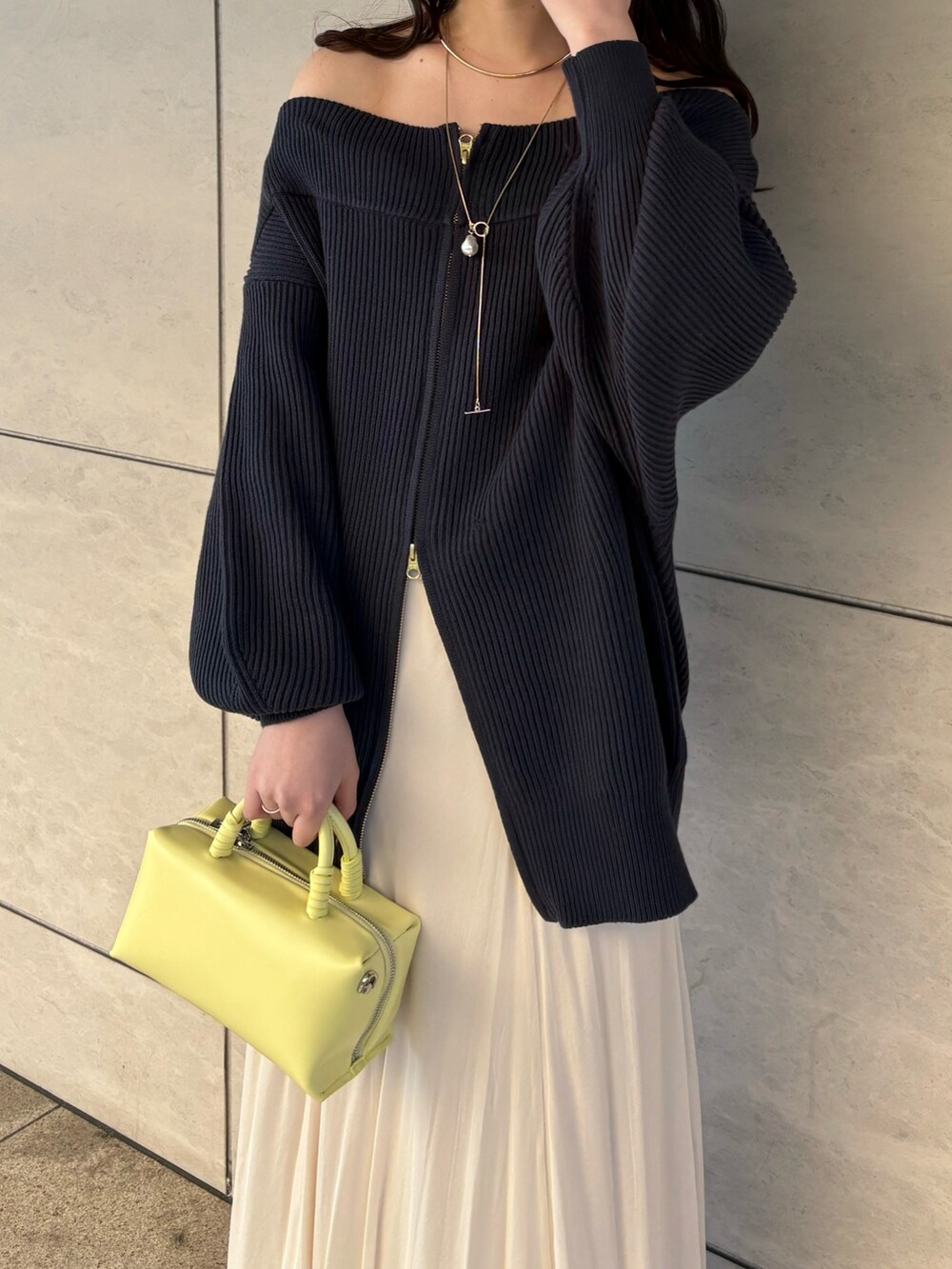 ブルー系のニット/セーター、ホワイト系のスカート、イエロー系のショルダーバッグを着用したレディースの冬コーディネートの4枚目の写真