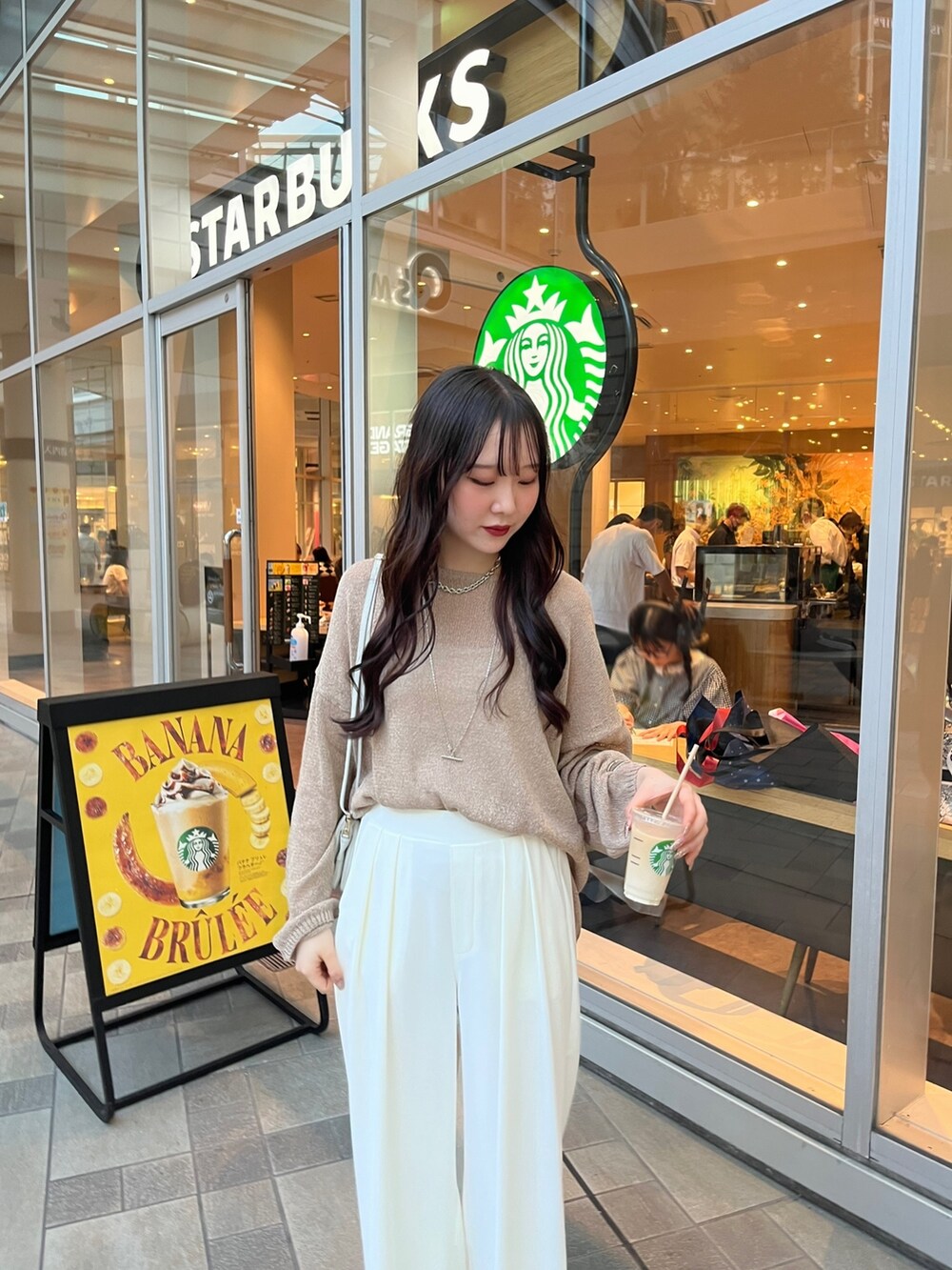 ブラウン系のニット/セーター、ホワイト系のスラックス、シルバー系のパンプスを着用したレディースの夏コーディネートの3枚目の写真