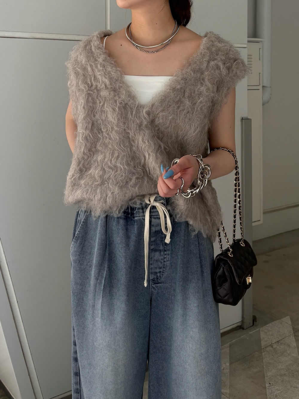 ベージュ系のニット/セーター、ブルー系のその他パンツ、ブラック系のショルダーバッグを着用したレディースの夏コーディネートの5枚目の写真