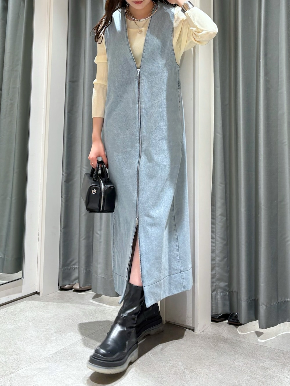 ブルー系のワンピース、ブラック系のショルダーバッグ、ホワイト系のニット/セーターを着用したレディースの冬コーディネートの3枚目の写真