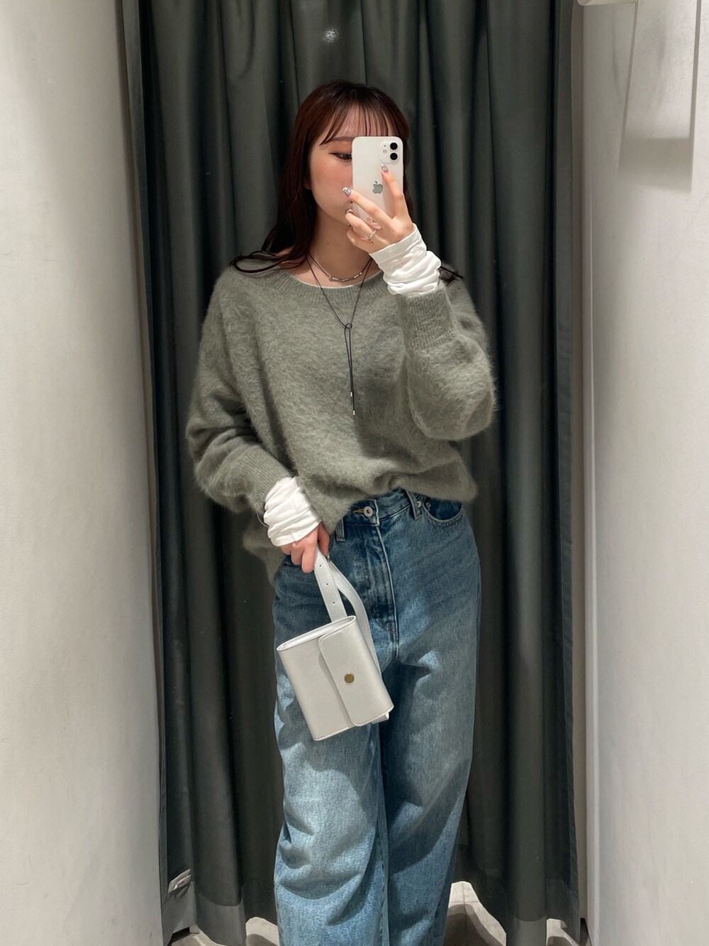 ブルー系のデニムパンツ、ブラック系のその他アウター、グリーン系のニット/セーターを着用したレディースの秋コーディネートの4枚目の写真