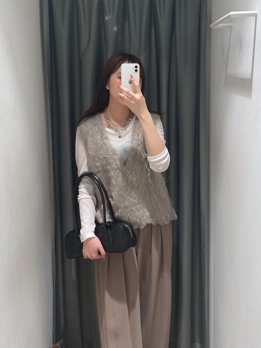 ブラウン系のスラックス、ベージュ系のニット/セーター、ホワイト系のTシャツ/カットソーを着用したレディースの秋コーディネートの2枚目の写真