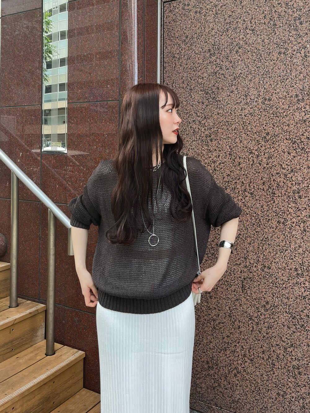 ブラウン系のニット/セーター、ホワイト系のスカート、シルバー系のサンダルを着用したレディースの夏コーディネートの6枚目の写真