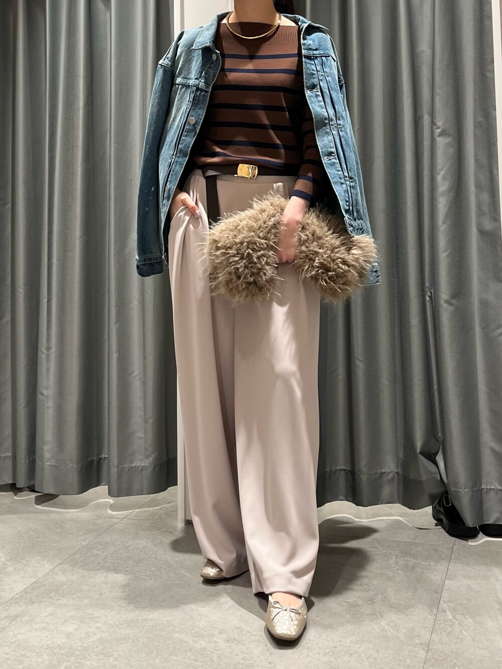 ベージュ系のショルダーバッグ、ベージュ系のスラックス、ブラウン系のニット/セーターを着用したレディースの秋コーディネートの2枚目の写真