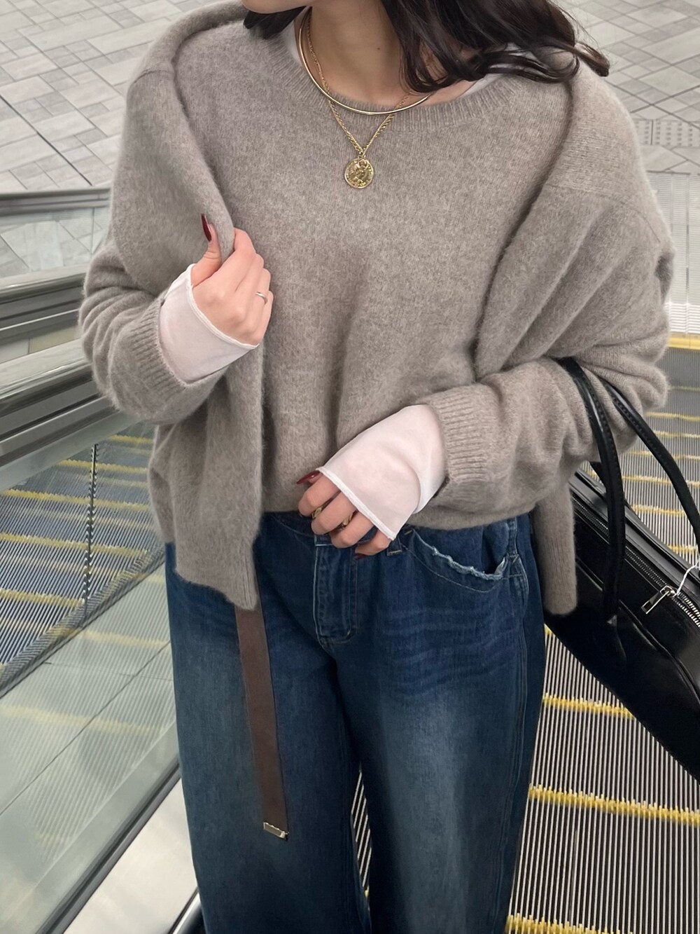 ブルー系のデニムパンツ、ブラウン系のニット/セーター、ブラウン系のカーディガン/ボレロを着用したレディースの冬コーディネートの5枚目の写真