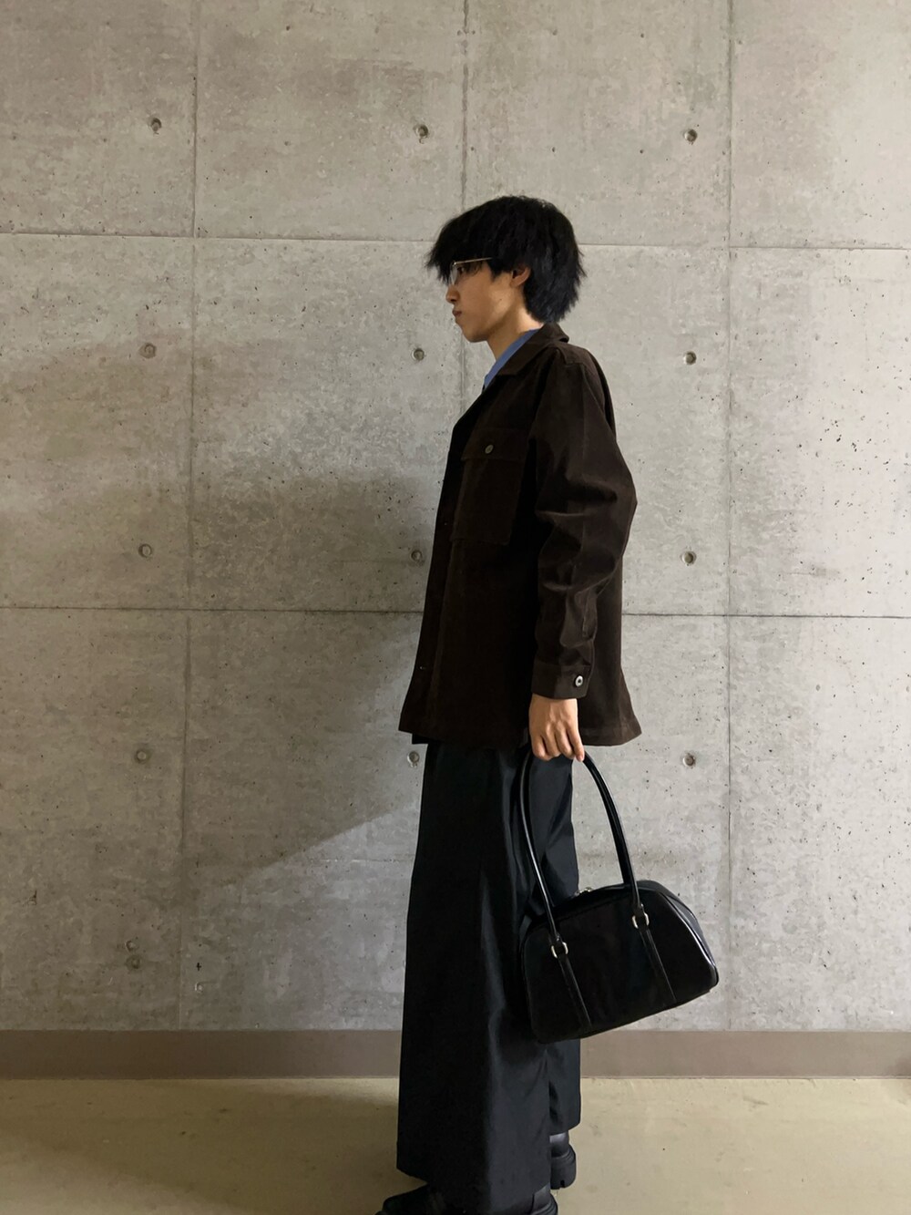 ブラック系のローファー、ブラック系のボストンバッグ、ブラウン系のその他アウターを着用したメンズの秋コーディネートの5枚目の写真