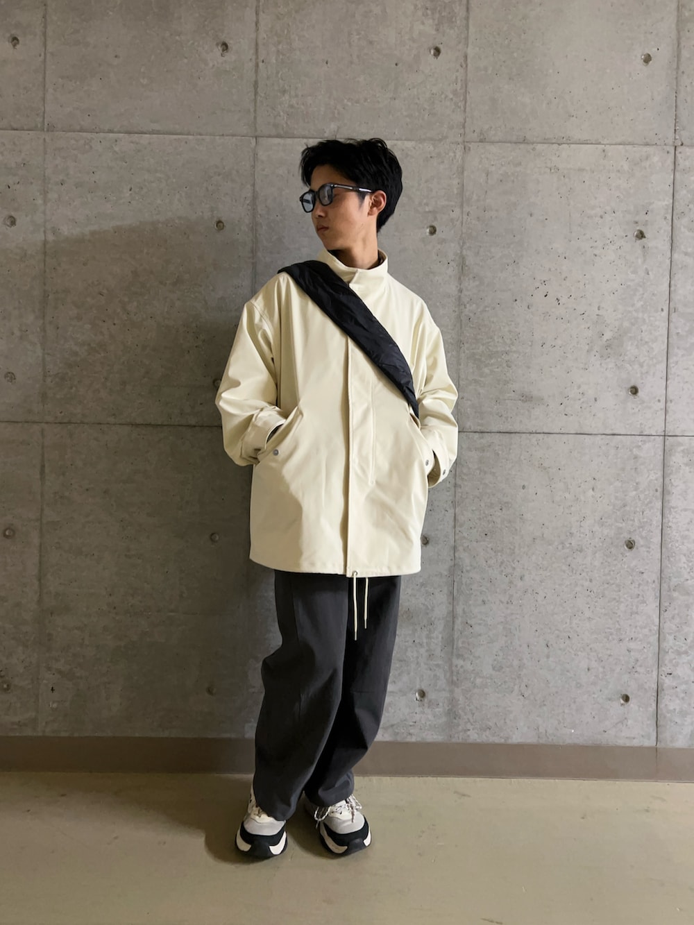 ホワイト系のミリタリージャケット、ブルー系のシャツ/ブラウス、ブラック系のショルダーバッグを着用したメンズの冬コーディネートの3枚目の写真