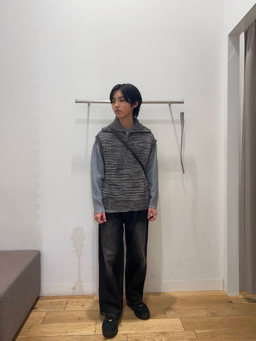 ブラック系のショルダーバッグ、グレー系のニット/セーター、ブラック系のデニムパンツを着用したメンズの冬コーディネートの3枚目の写真