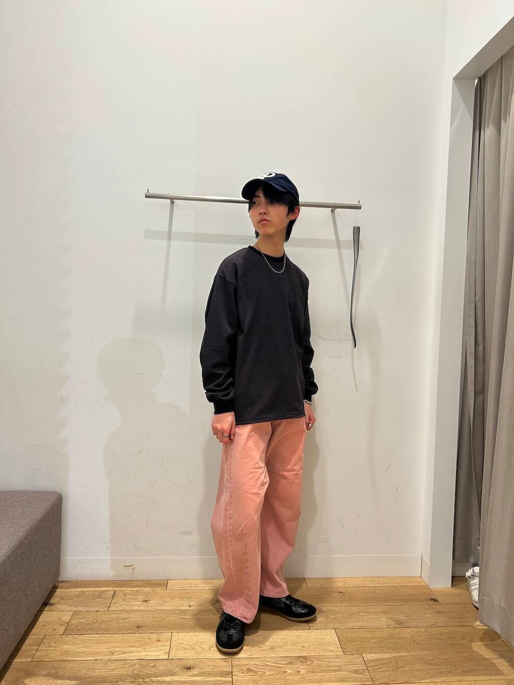 ブラック系のスニーカー、ピンク系のデニムパンツ、ブラウン系のTシャツ/カットソーを着用したメンズの冬コーディネートの2枚目の写真