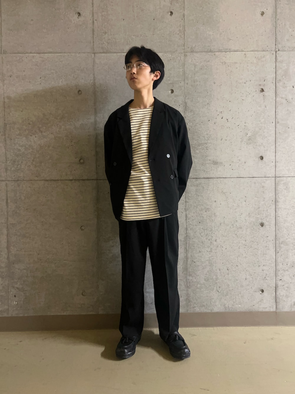 ブラック系のスラックス、ブラック系のテーラードジャケット、ホワイト系のTシャツ/カットソーを着用したメンズの春コーディネートの2枚目の写真