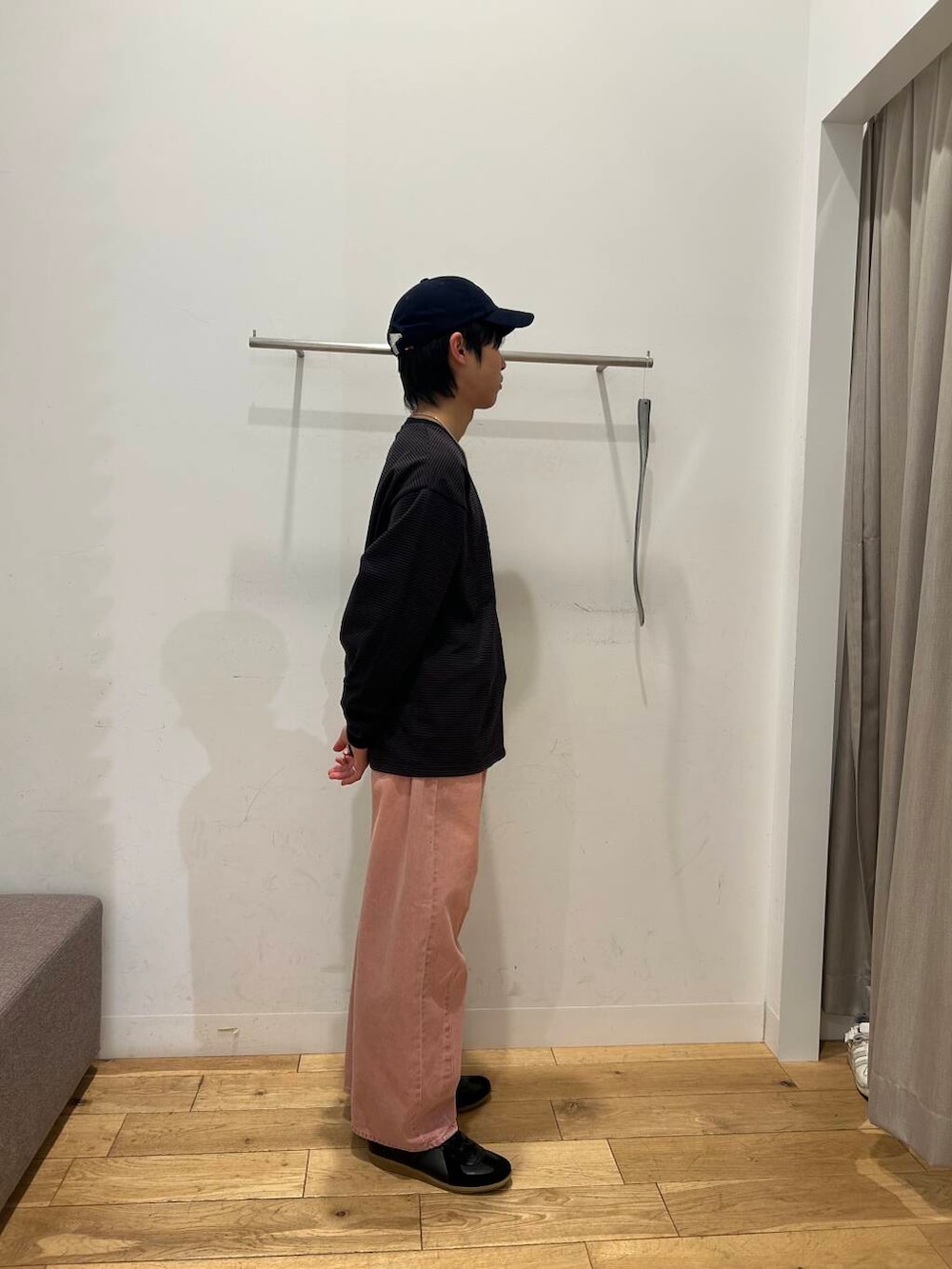 ブラック系のスニーカー、ピンク系のデニムパンツ、ブラウン系のTシャツ/カットソーを着用したメンズの冬コーディネートの4枚目の写真