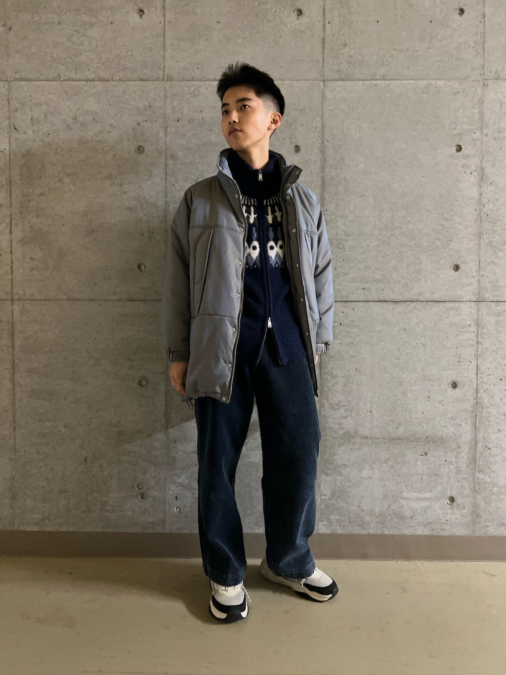 グリーン系のダウンジャケット/コート、ブルー系のニット/セーター、ブルー系のその他パンツを着用したメンズの秋コーディネートの2枚目の写真