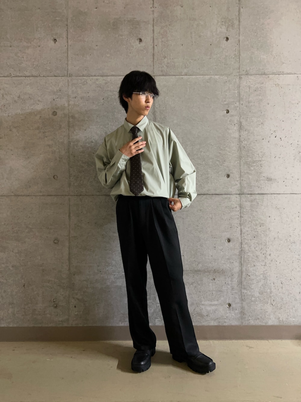 ブラウン系のネクタイ、ブラック系のその他パンツ、グリーン系のシャツ/ブラウスを着用したメンズの秋コーディネートの4枚目の写真