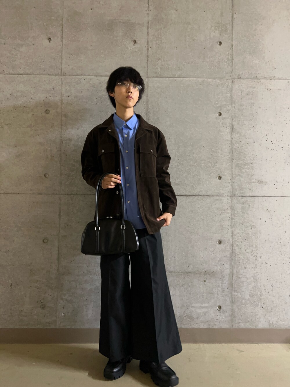 ブラック系のローファー、ブラック系のボストンバッグ、ブラウン系のその他アウターを着用したメンズの秋コーディネートの4枚目の写真