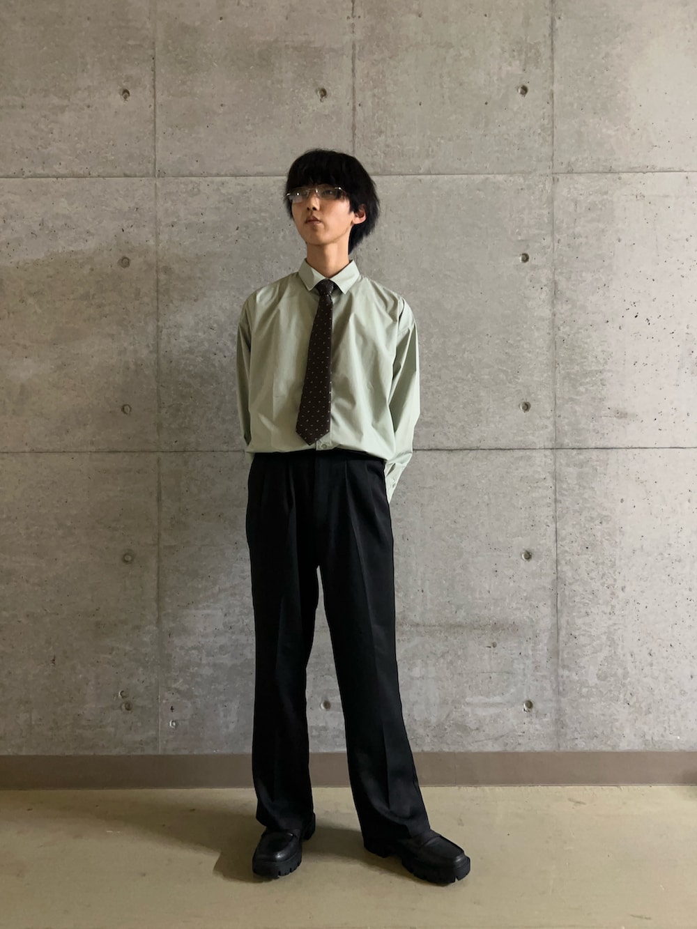 ブラウン系のネクタイ、ブラック系のその他パンツ、グリーン系のシャツ/ブラウスを着用したメンズの秋コーディネートの3枚目の写真