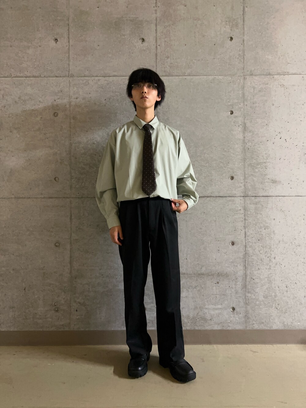 ブラウン系のネクタイ、ブラック系のその他パンツ、グリーン系のシャツ/ブラウスを着用したメンズの秋コーディネートの2枚目の写真