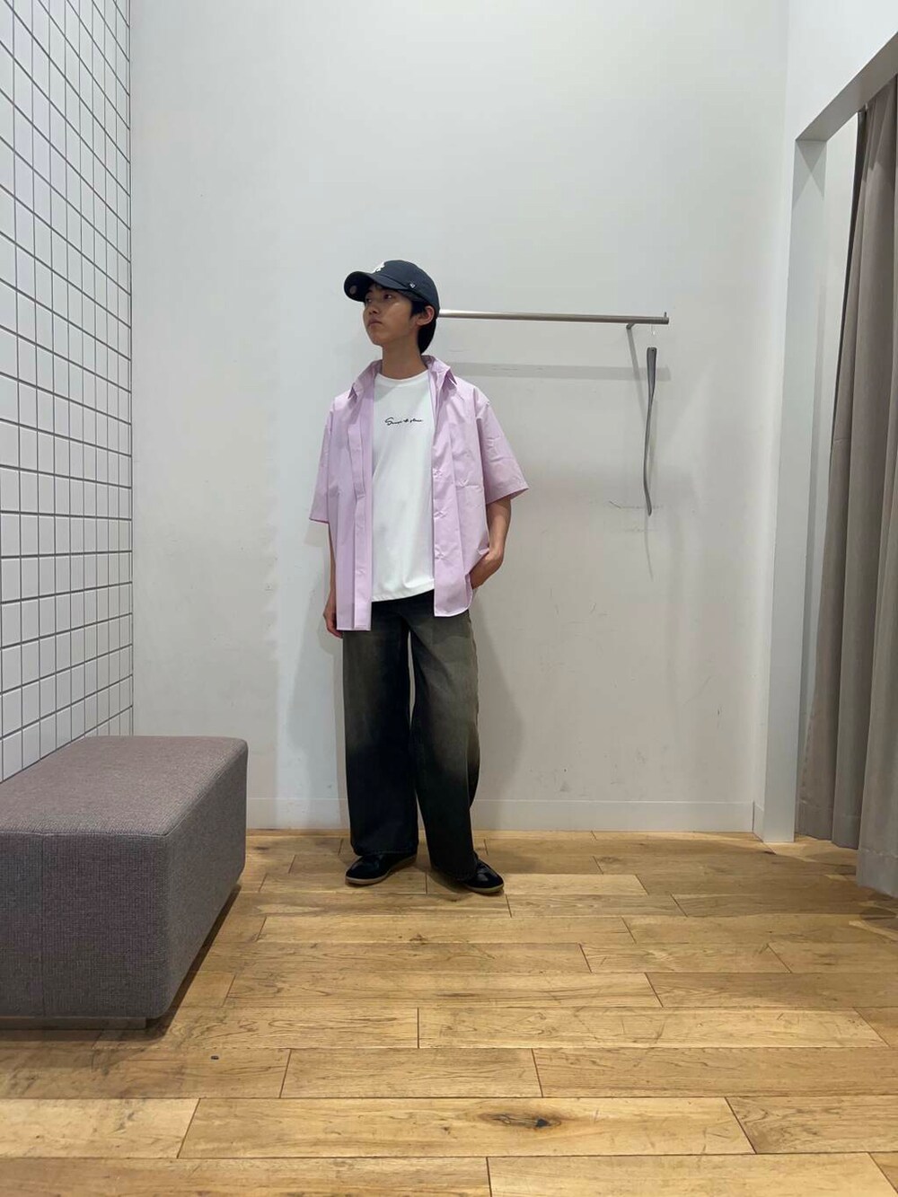 ブラック系のスニーカー、ホワイト系のTシャツ/カットソー、ブラック系のデニムパンツを着用したメンズの春コーディネートの2枚目の写真