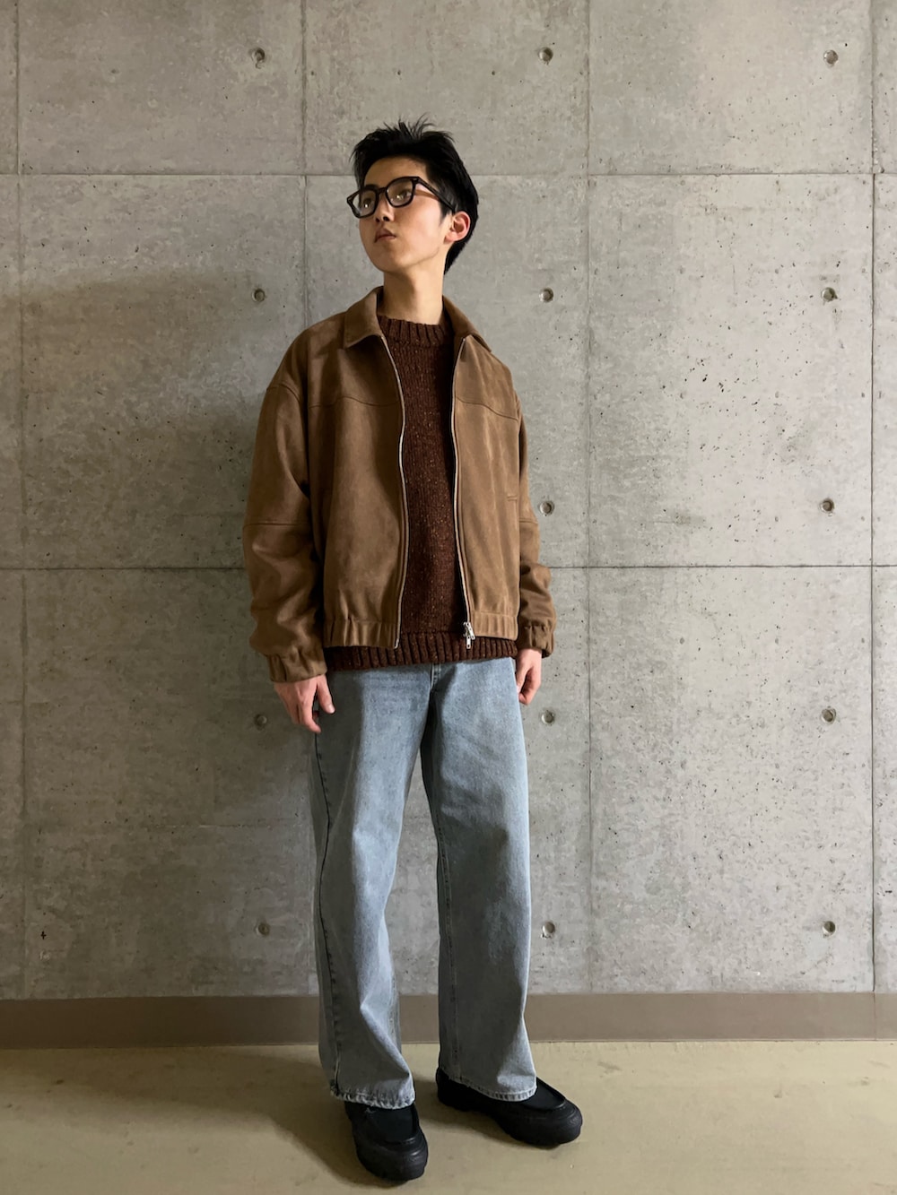 ブラウン系のニット/セーター、ベージュ系のブルゾン、ブルー系のデニムパンツを着用したメンズの冬コーディネートの2枚目の写真