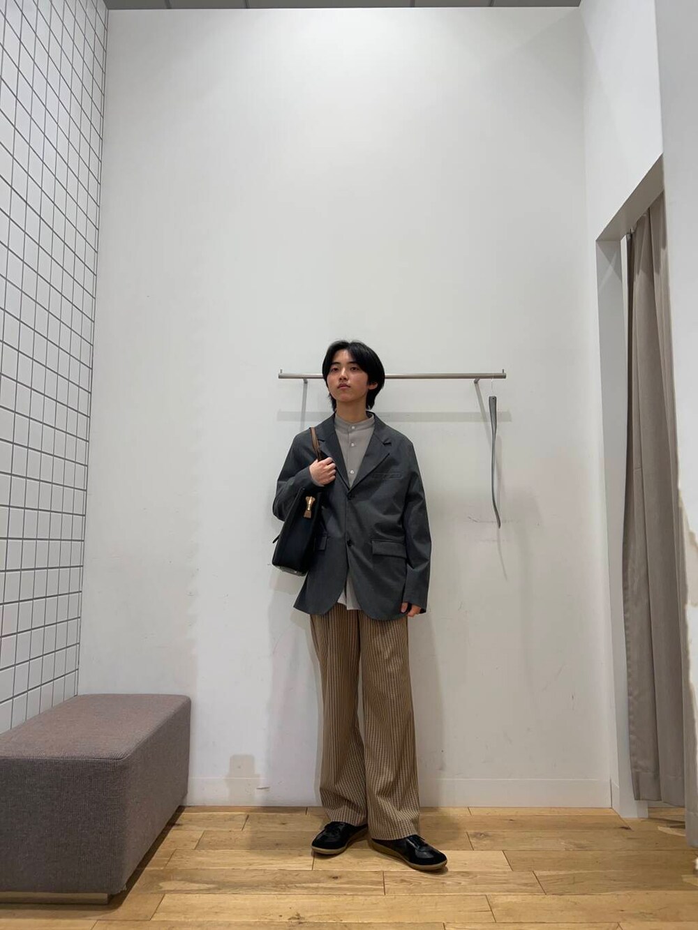 ブラック系のトートバッグ、ブラウン系のその他パンツ、ブラック系のスニーカーを着用したメンズの春コーディネートの3枚目の写真