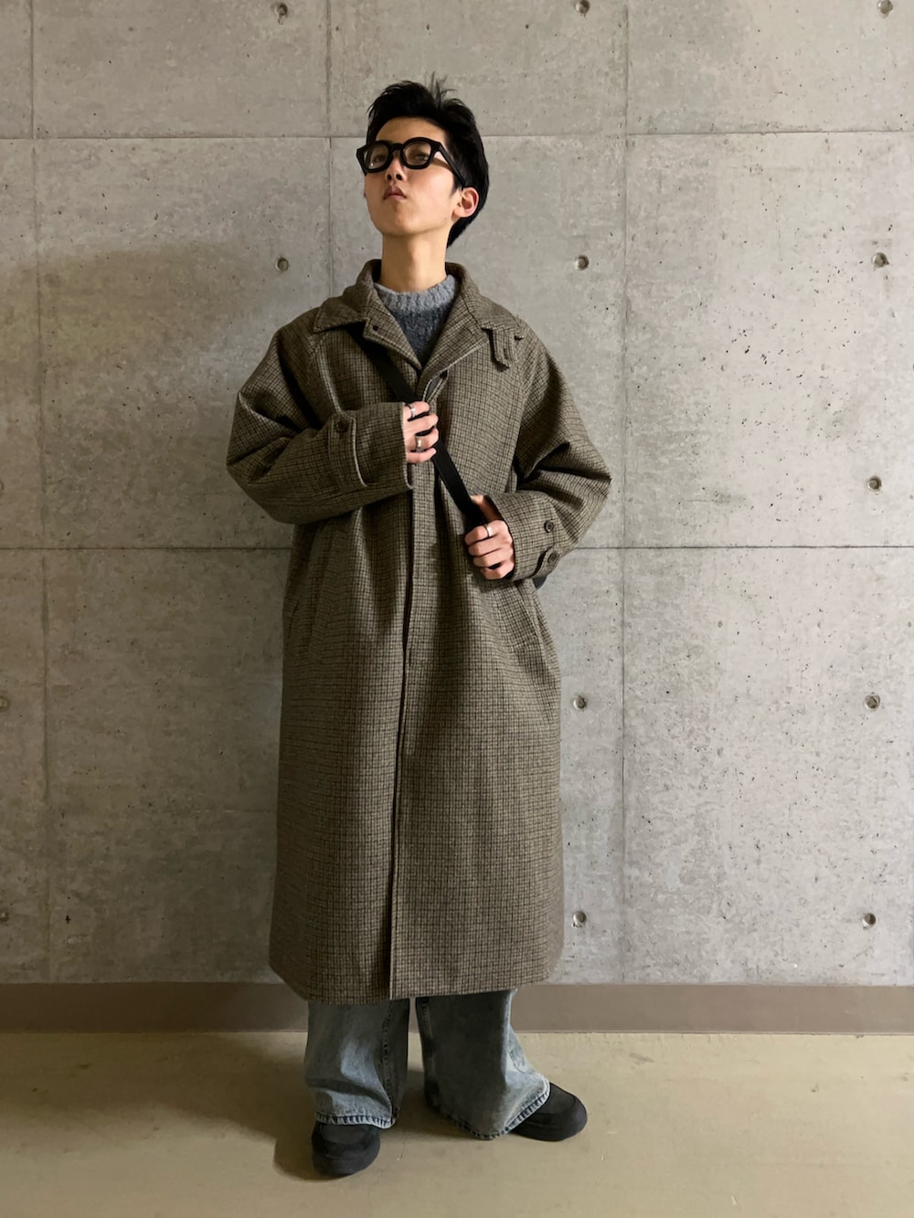 ブルー系のデニムパンツ、グレー系のニット/セーター、ブラウン系のその他アウターを着用したメンズの冬コーディネートの3枚目の写真