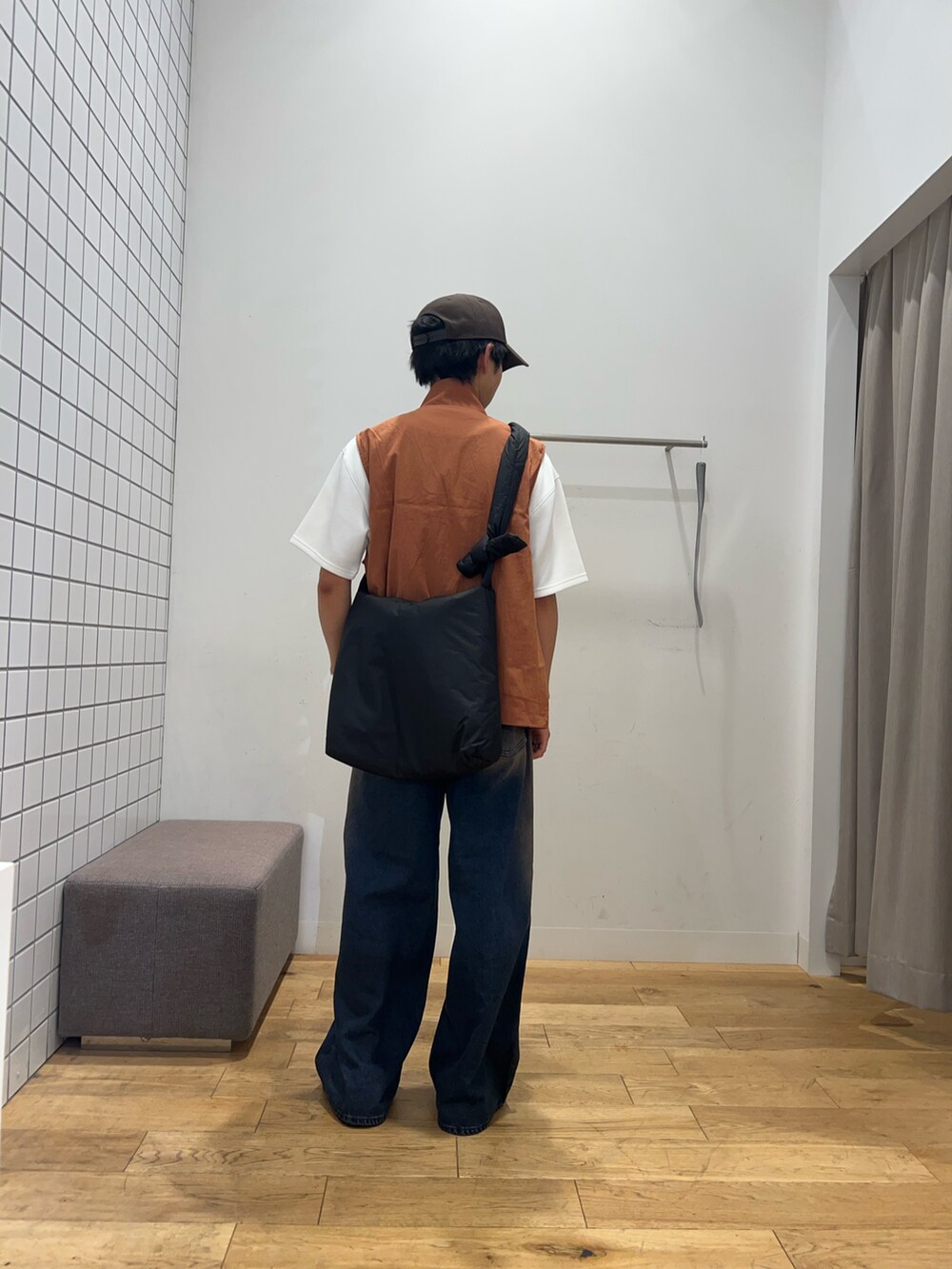 ブラック系のショルダーバッグ、ホワイト系のTシャツ/カットソー、オレンジ系のブルゾンを着用したメンズの秋コーディネートの2枚目の写真