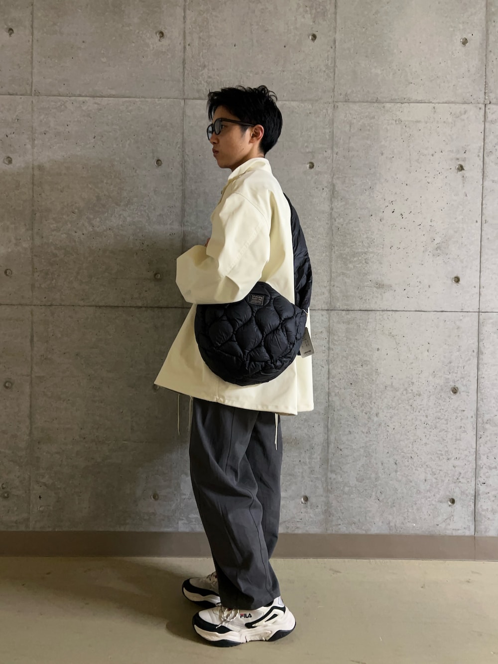 ホワイト系のミリタリージャケット、ブルー系のシャツ/ブラウス、ブラック系のショルダーバッグを着用したメンズの冬コーディネートの6枚目の写真