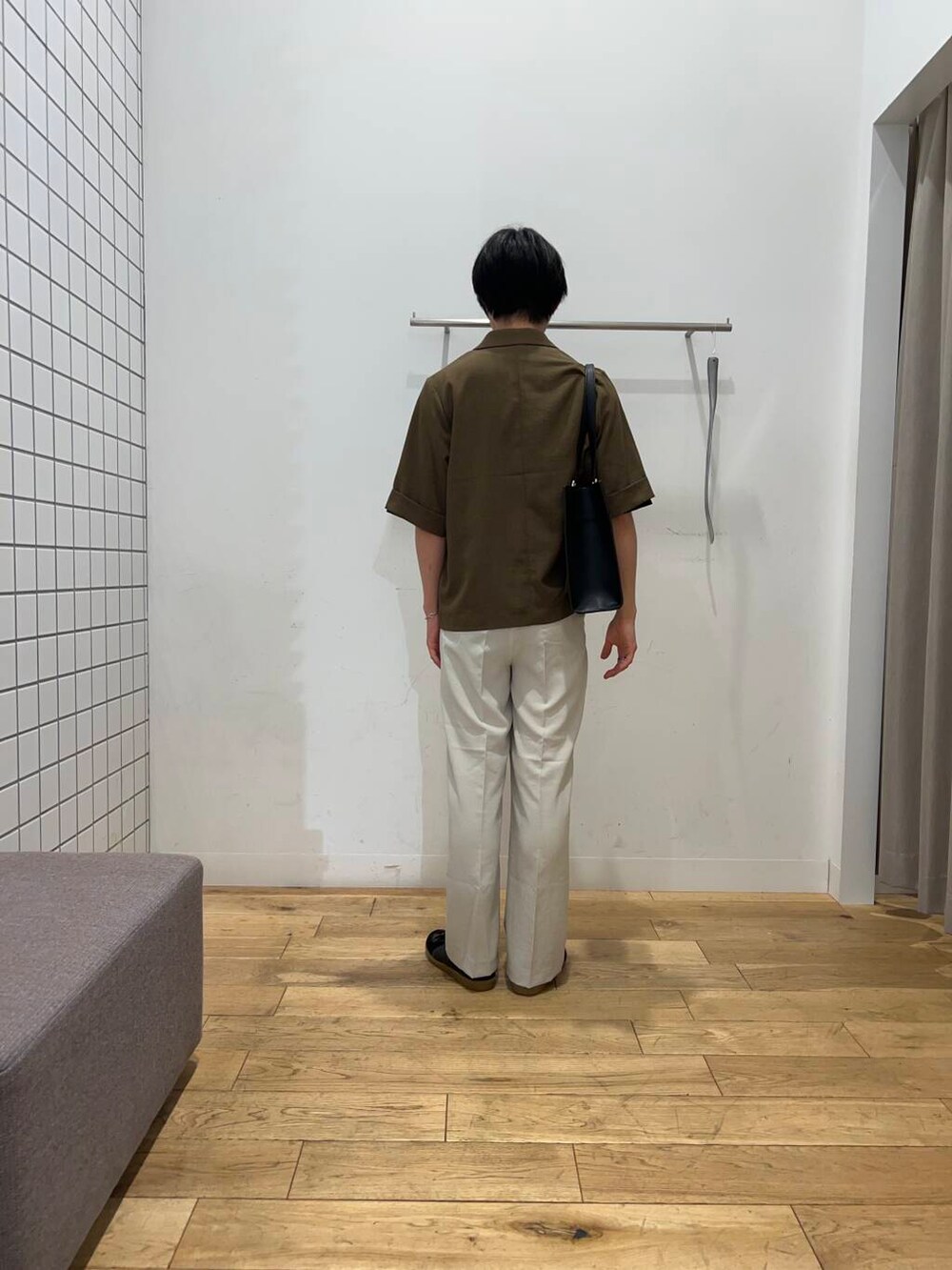 ブラック系のスニーカー、ブラック系のトートバッグ、ベージュ系のその他パンツを着用したメンズの春コーディネートの3枚目の写真