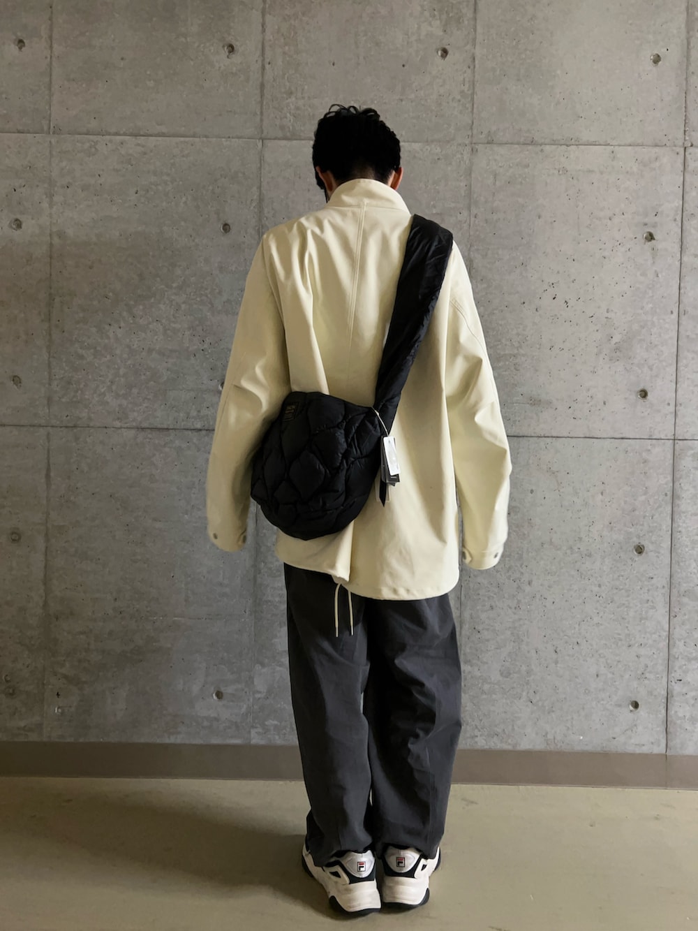 ホワイト系のミリタリージャケット、ブルー系のシャツ/ブラウス、ブラック系のショルダーバッグを着用したメンズの冬コーディネートの7枚目の写真