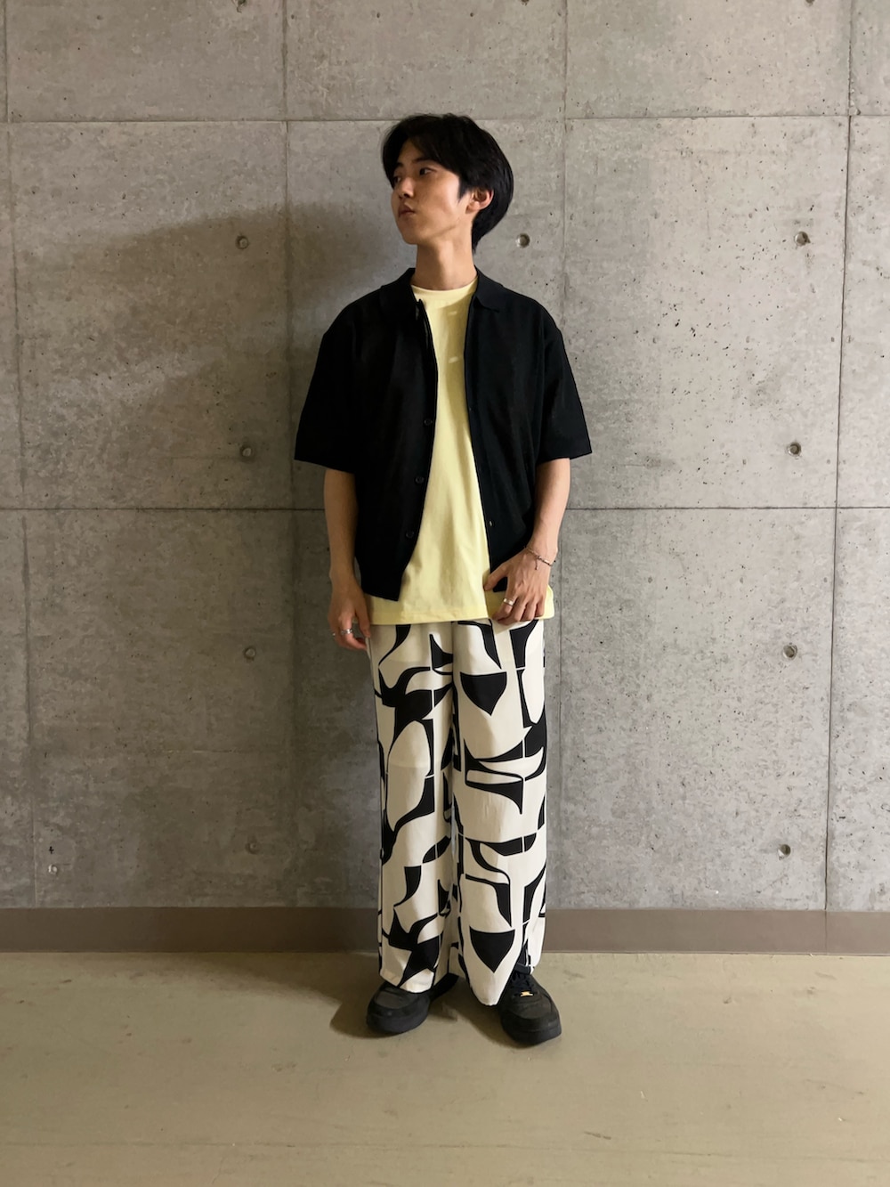 イエロー系のTシャツ/カットソー、ブラック系のその他パンツ、ブラック系のニット/セーターを着用したメンズの夏コーディネートの2枚目の写真