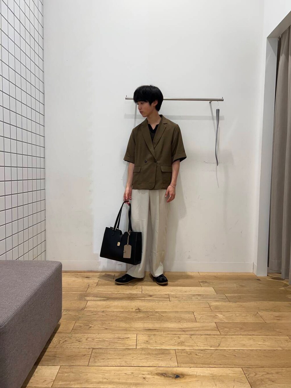 ブラック系のスニーカー、ブラック系のトートバッグ、ベージュ系のその他パンツを着用したメンズの春コーディネートの2枚目の写真