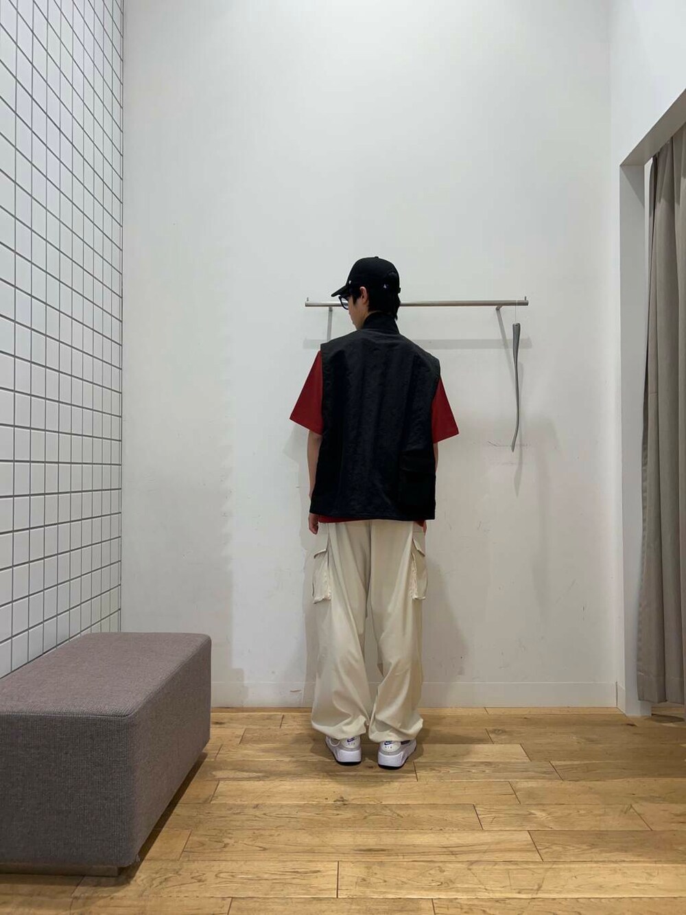 ブラック系のその他アウター、ベージュ系のその他パンツ、レッド系のTシャツ/カットソーを着用したメンズの春コーディネートの5枚目の写真