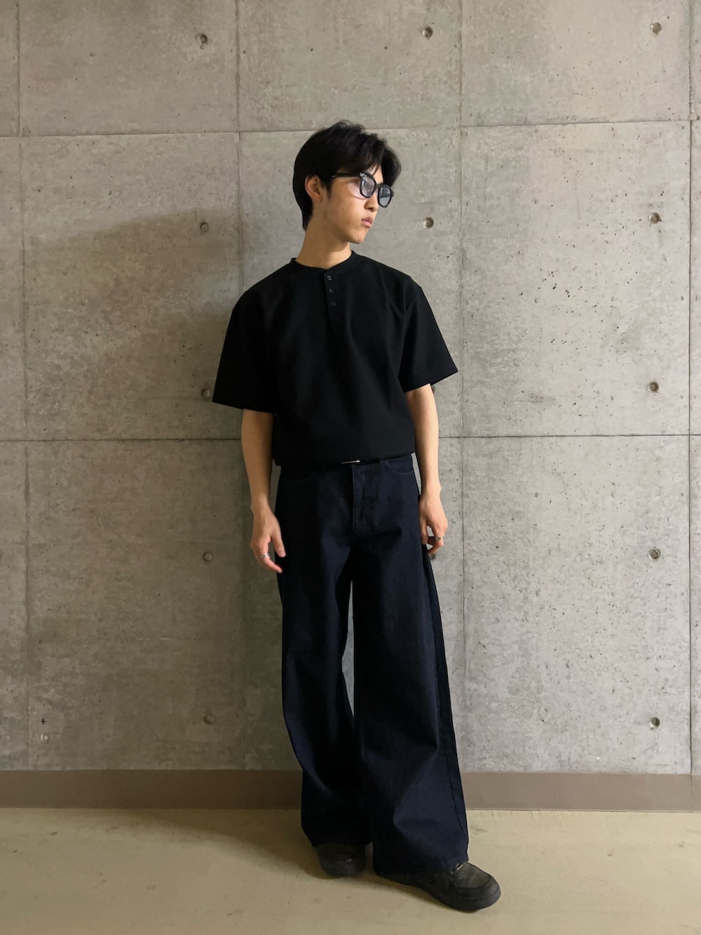 ブラック系のTシャツ/カットソー、ブルー系のデニムパンツ、ブルー系のサングラスを着用したメンズの夏コーディネートの3枚目の写真