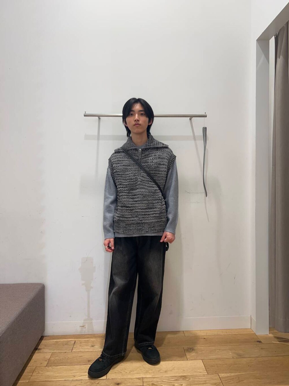 ブラック系のショルダーバッグ、グレー系のニット/セーター、ブラック系のデニムパンツを着用したメンズの冬コーディネートの2枚目の写真