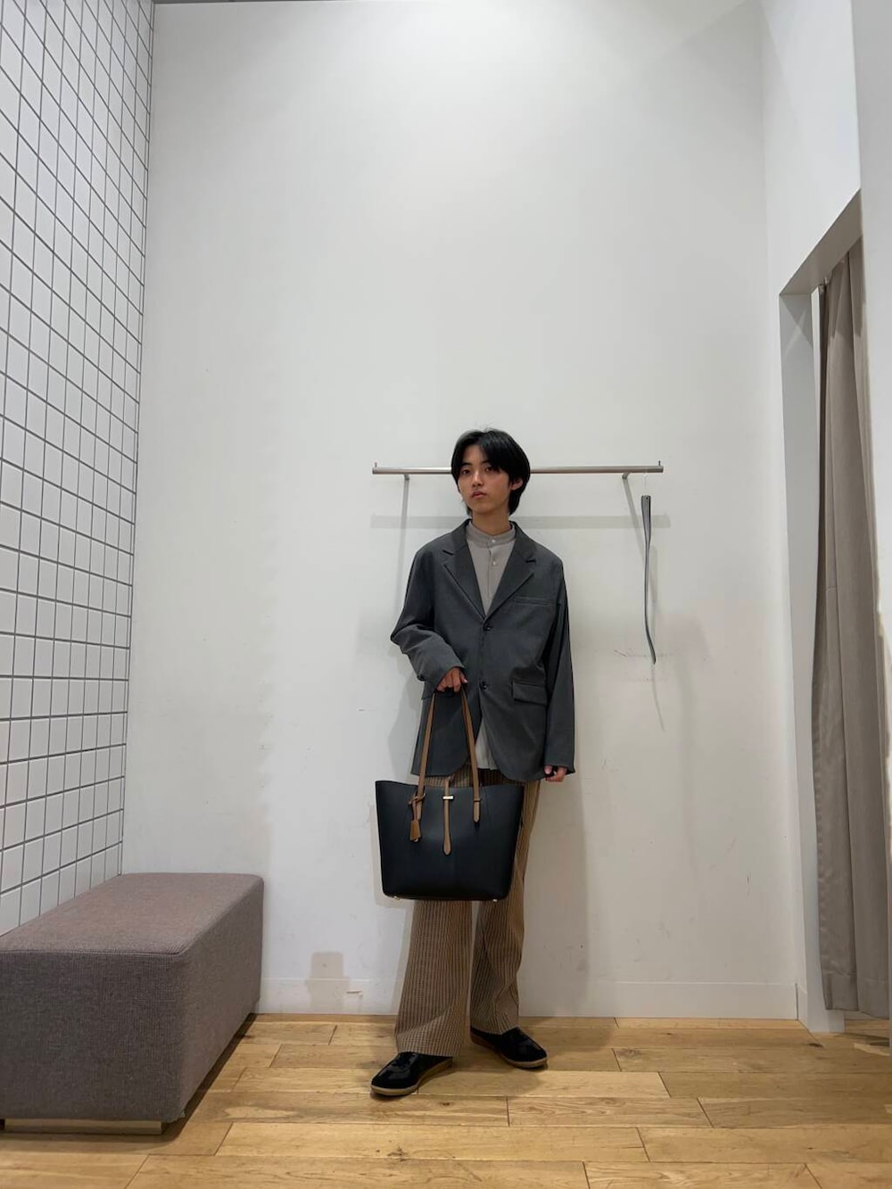 ブラック系のトートバッグ、ブラウン系のその他パンツ、ブラック系のスニーカーを着用したメンズの春コーディネートの2枚目の写真