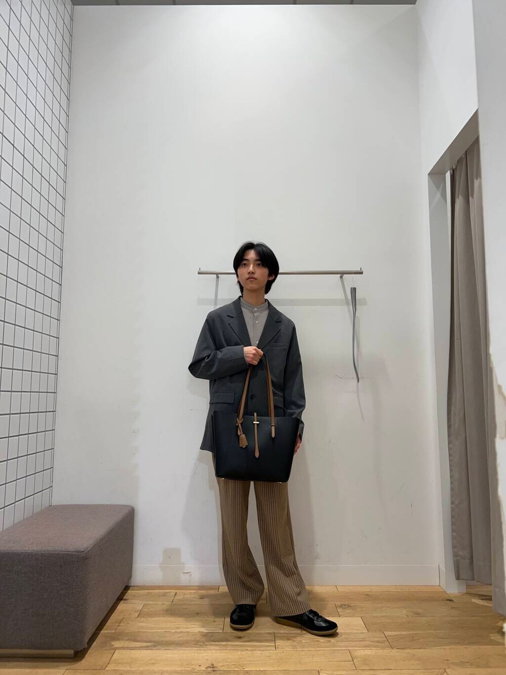 ブラック系のトートバッグ、ブラウン系のその他パンツ、ブラック系のスニーカーを着用したメンズの春コーディネートの4枚目の写真