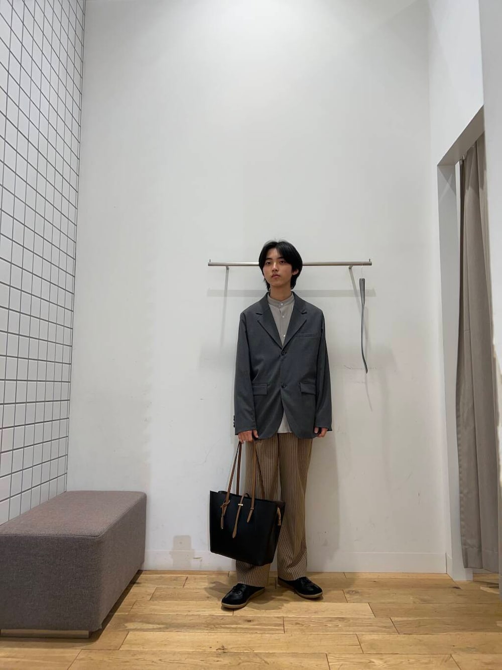 ブラック系のトートバッグ、ブラウン系のその他パンツ、ブラック系のスニーカーを着用したメンズの春コーディネートの5枚目の写真