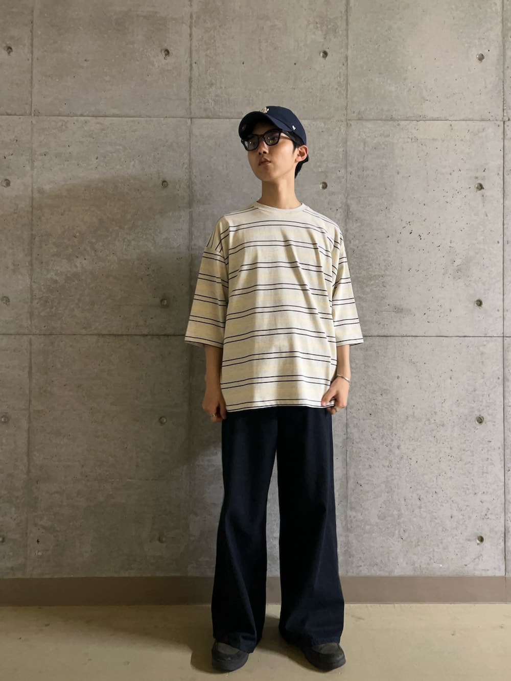 グレー系のTシャツ/カットソー、ブルー系のデニムパンツ、ブラック系のサングラスを着用したメンズの夏コーディネートの3枚目の写真