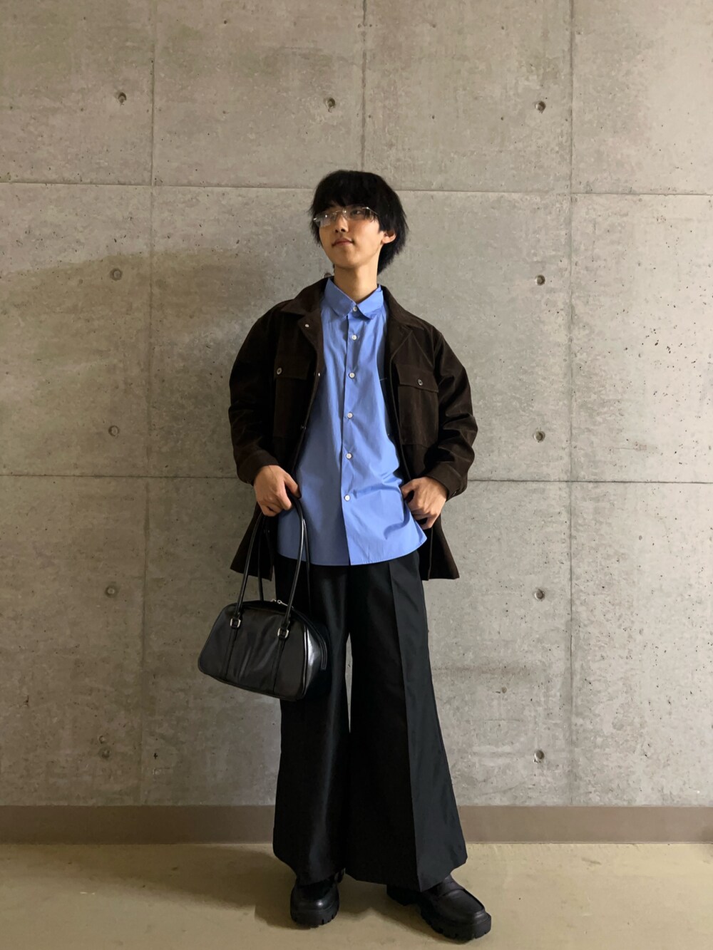 ブラック系のローファー、ブラック系のボストンバッグ、ブラウン系のその他アウターを着用したメンズの秋コーディネートの2枚目の写真