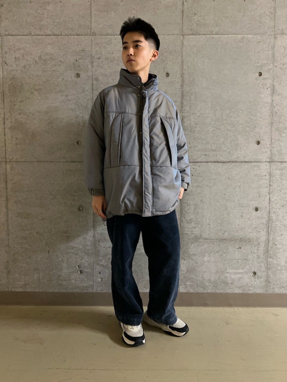 グリーン系のダウンジャケット/コート、ブルー系のニット/セーター、ブルー系のその他パンツを着用したメンズの秋コーディネートの3枚目の写真