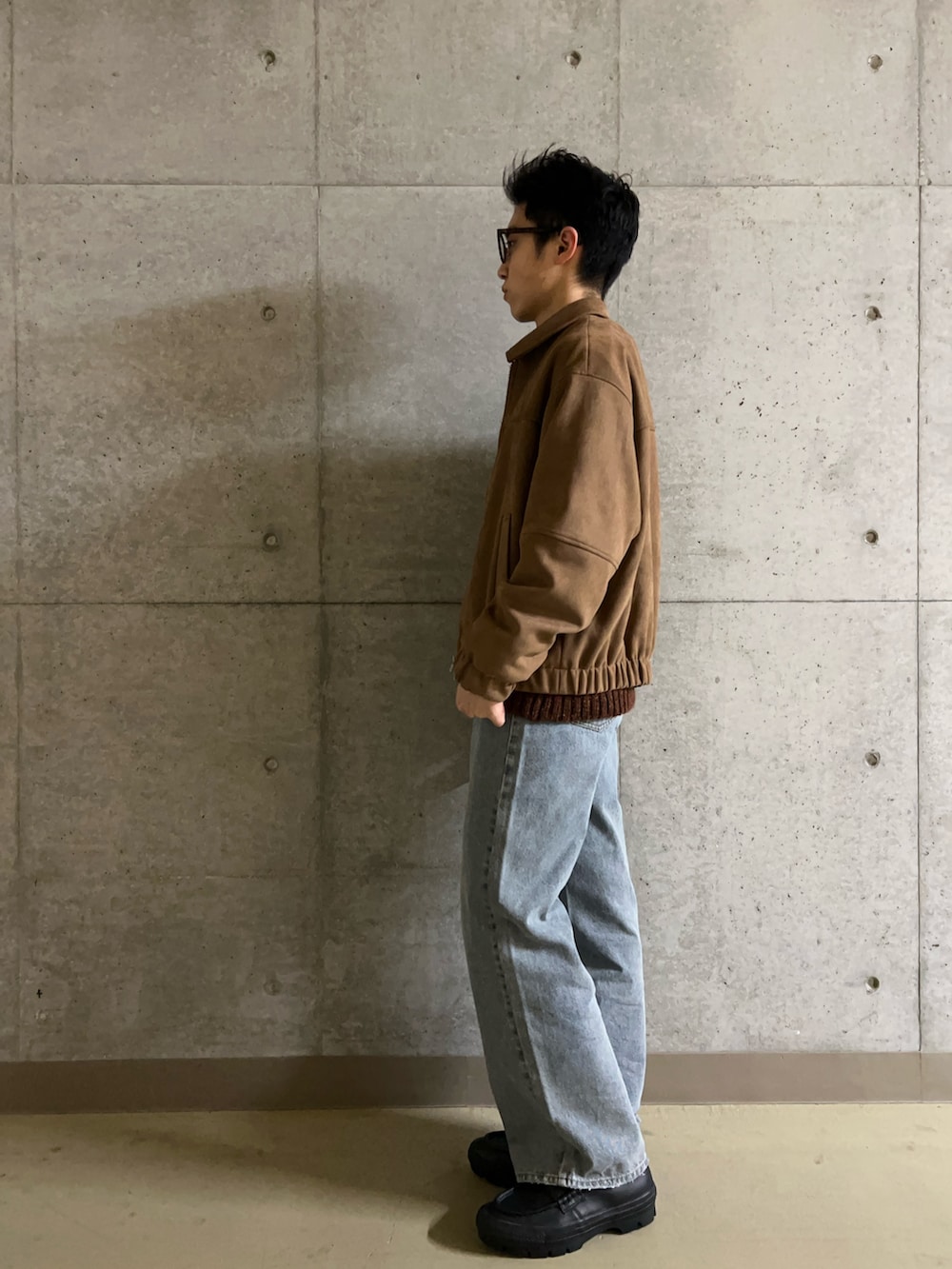 ブラウン系のニット/セーター、ベージュ系のブルゾン、ブルー系のデニムパンツを着用したメンズの冬コーディネートの3枚目の写真