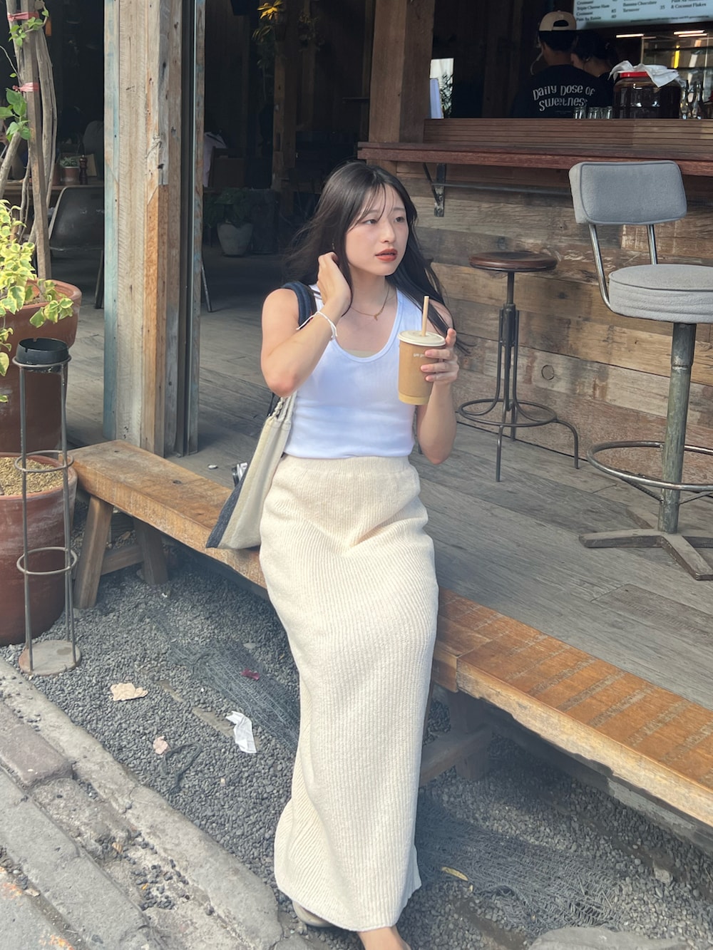 ベージュ系のサンダル、ホワイト系のスカート、ホワイト系のタンクトップを着用したレディースの秋コーディネートの2枚目の写真