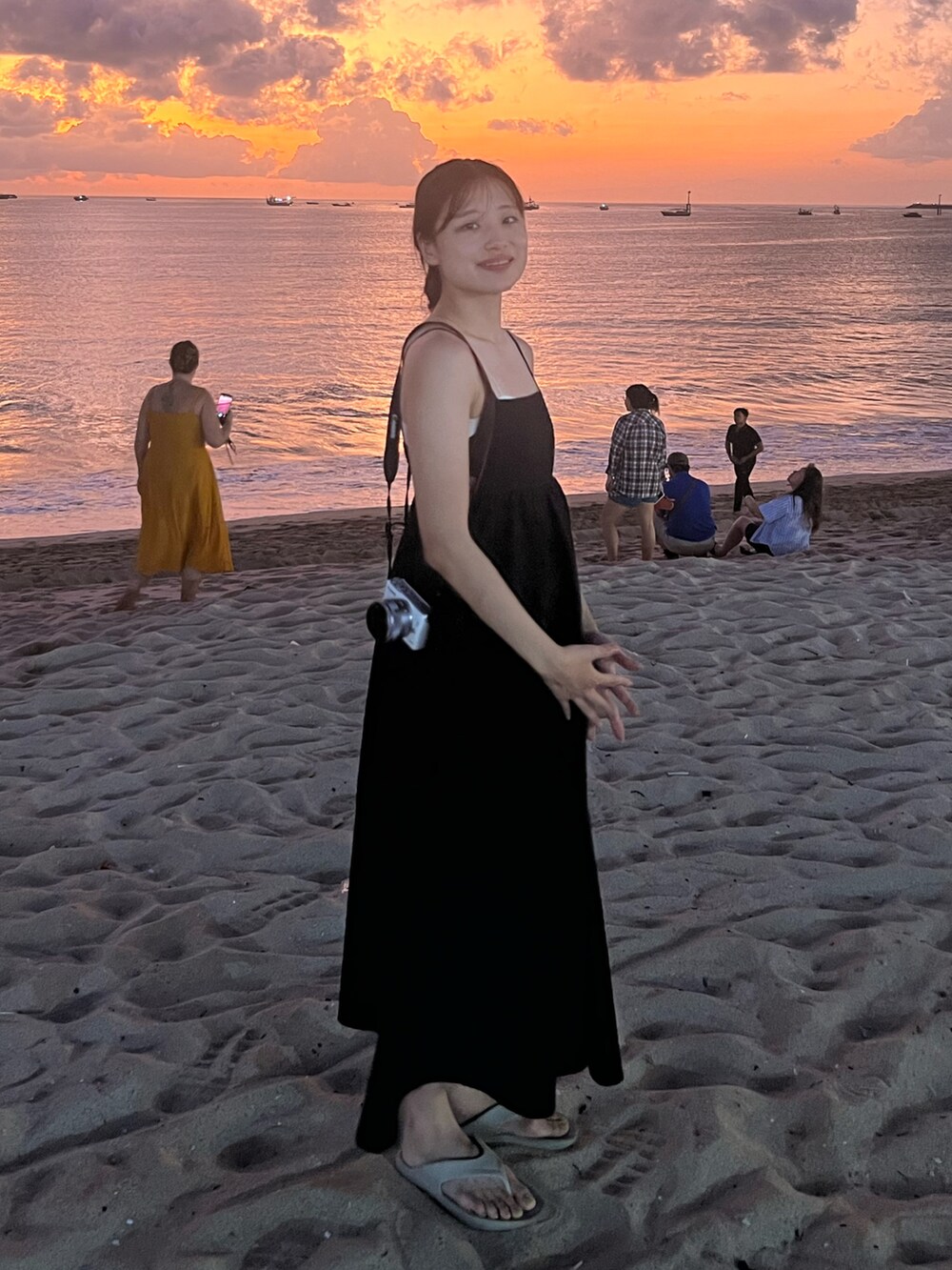 ブラック系のジャンパースカート、ベージュ系のサンダルを着用したレディースの秋コーディネートの2枚目の写真