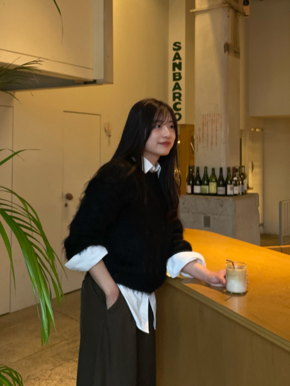 ブラック系のニット/セーター、ブラウン系のスラックス、ブラック系のローファーを着用したレディースの冬コーディネートの2枚目の写真