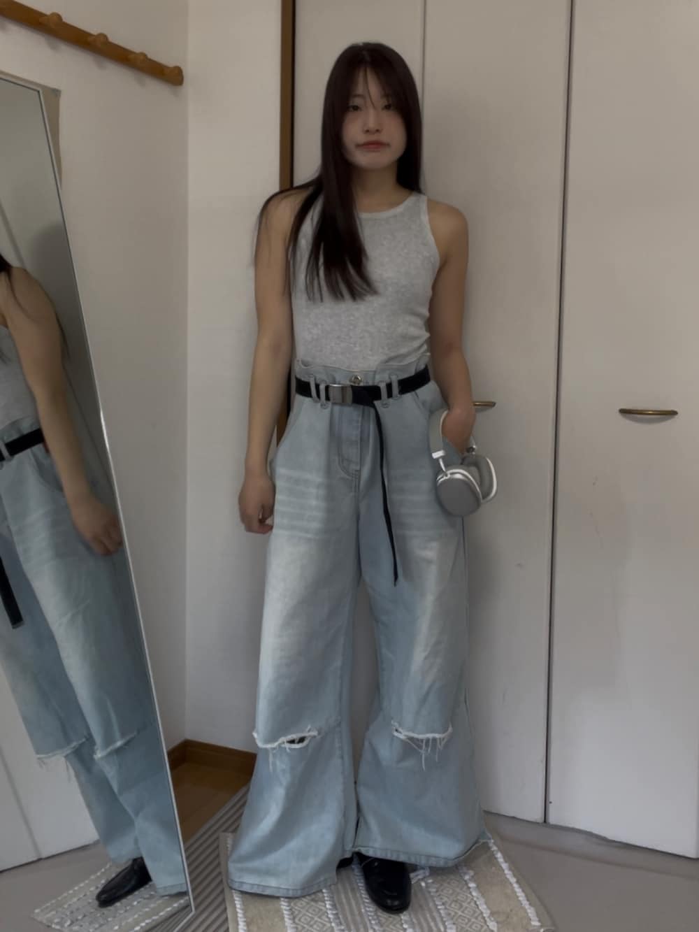 ブルー系のデニムパンツ、グレー系のタンクトップを着用したレディースの春コーディネートの2枚目の写真