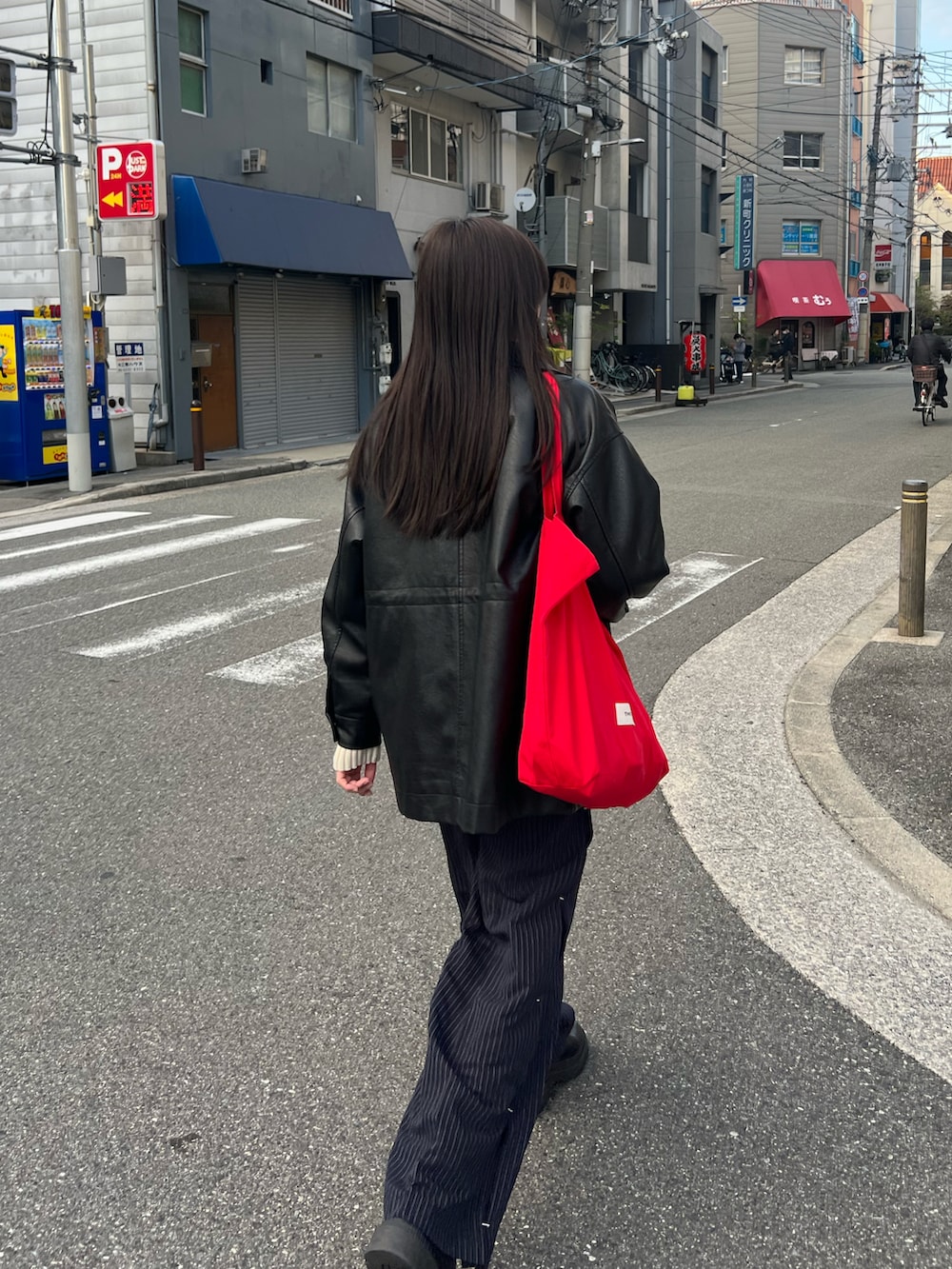ブラック系のその他アウター、ブルー系のその他パンツ、ホワイト系のニット/セーターを着用したレディースの秋コーディネートの2枚目の写真